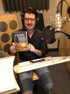 Actor Rob Doyle holding his copy of Carpe Diem, Illinois