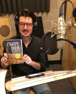 Actor Rob Doyle holding his copy of Carpe Diem, Illinois