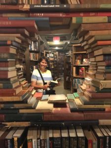 Kristin looking through a tunnel of books at The Last Bookstore