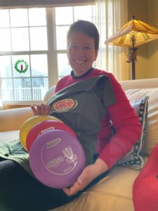 Kristin with three discs and a disc golf t-shirt