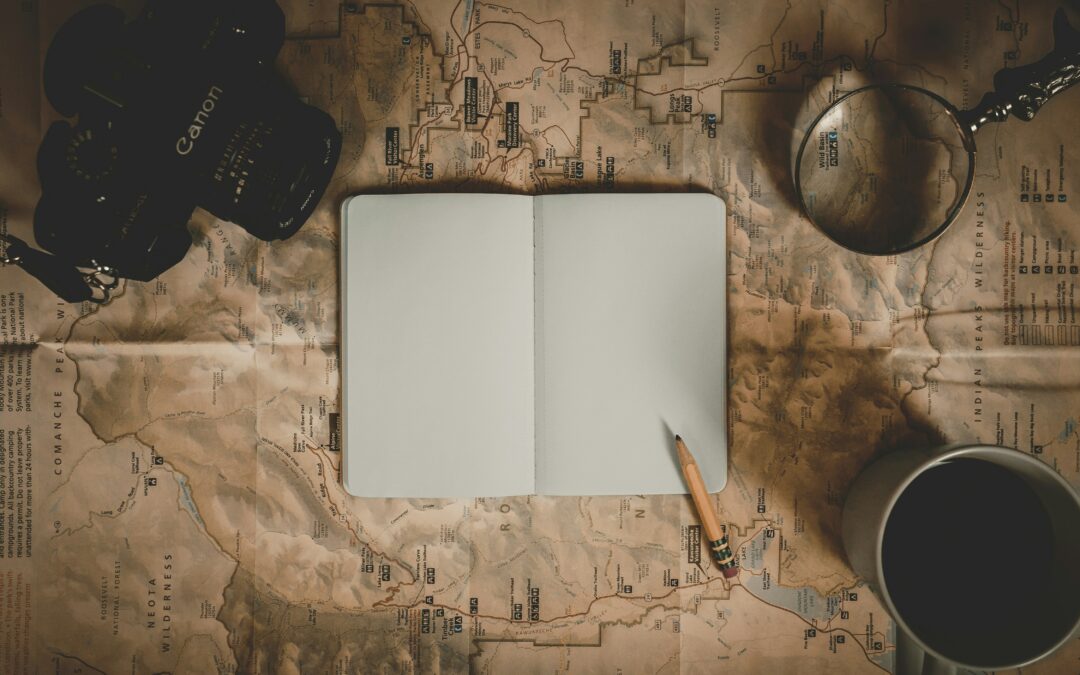 open book on map with camera and magnifying glass