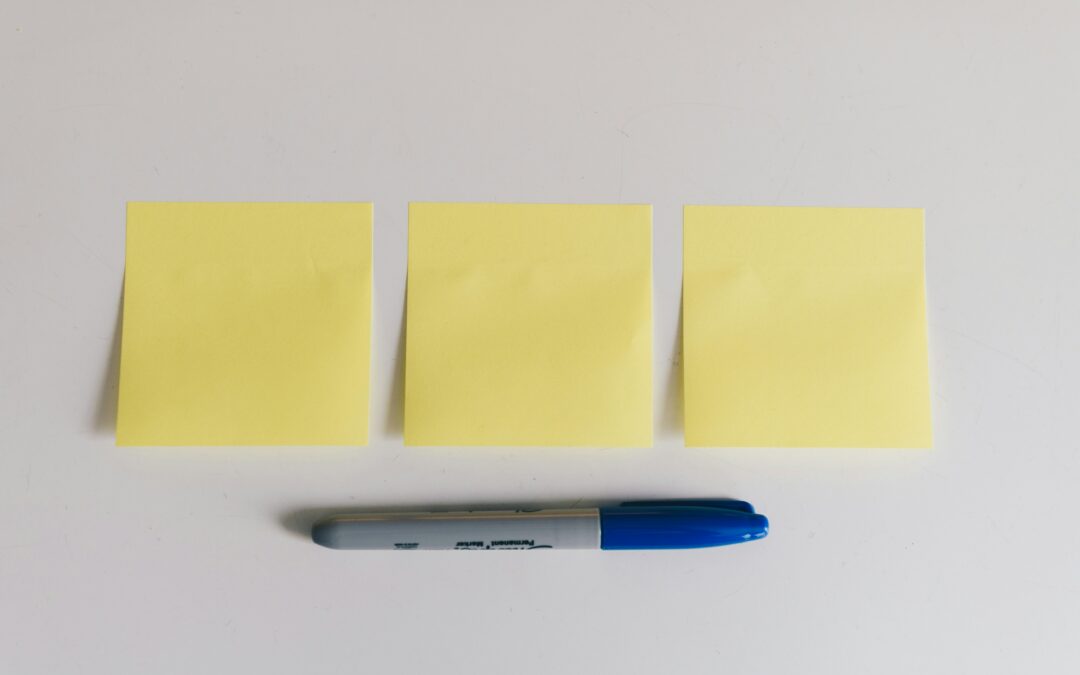 Three yellow post-it notes and a blue marker.